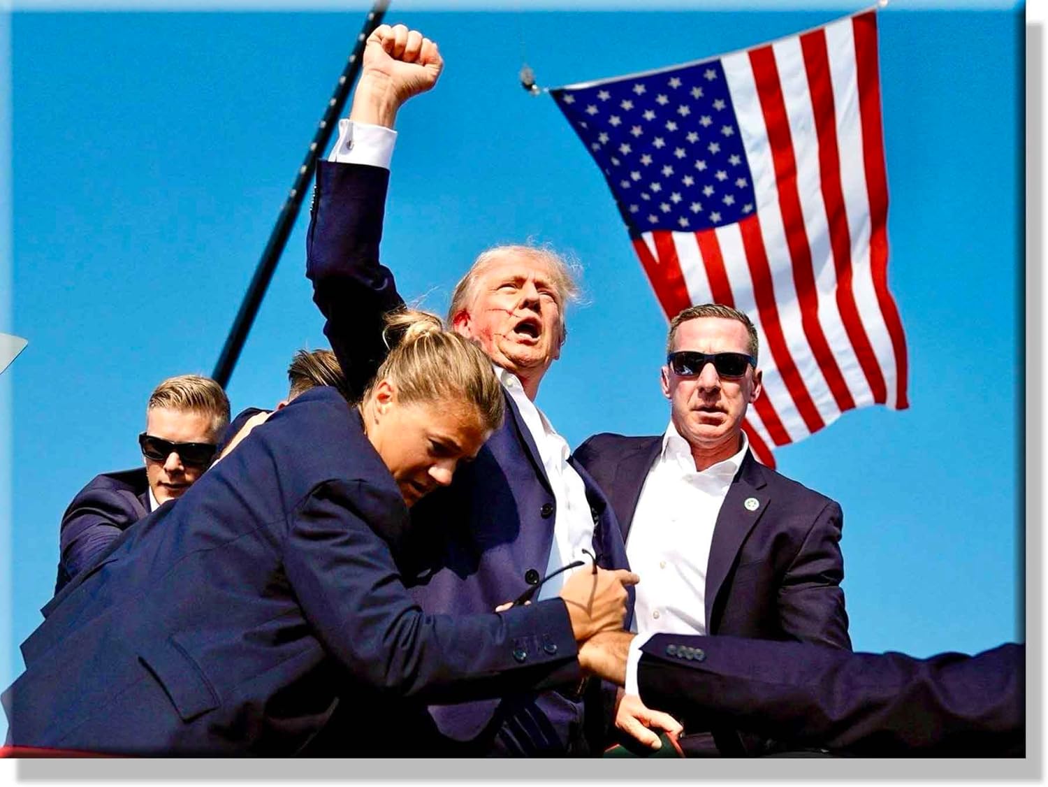 Trump with Secret Service agents raising fist after assassination attempt